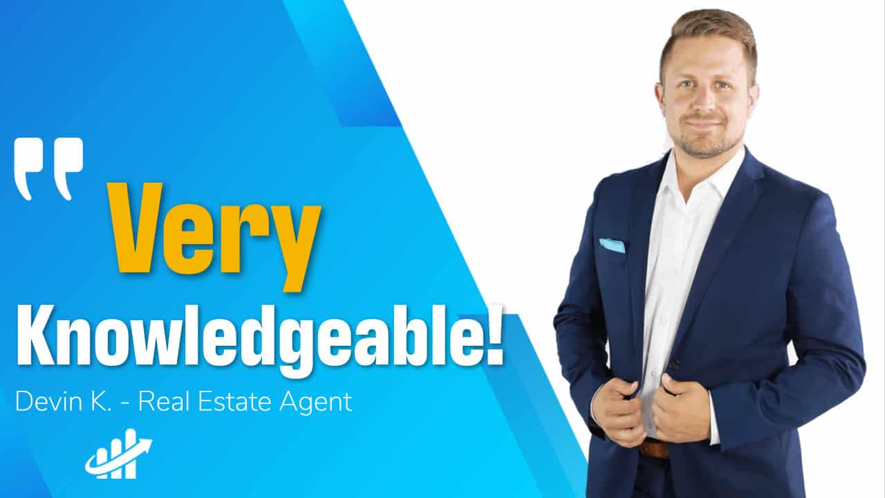 A very knowledgable man in a suit standing in front of a blue background.