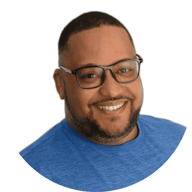 Preston Martelly with glasses smiling, wearing a blue shirt against a white background.