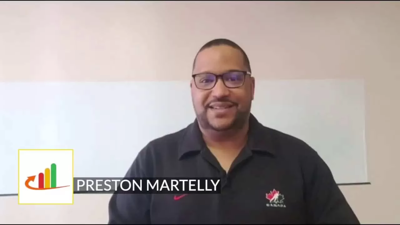 Preston martelly - a man in a black shirt standing in front of a white wall.