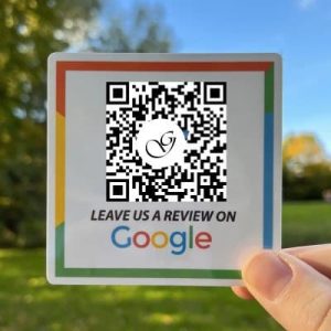 A person holding a QR code promoting leaving a Google review.