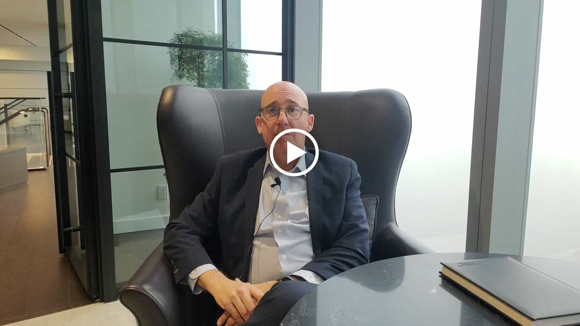 A man, dressed formally, occupying a chair.