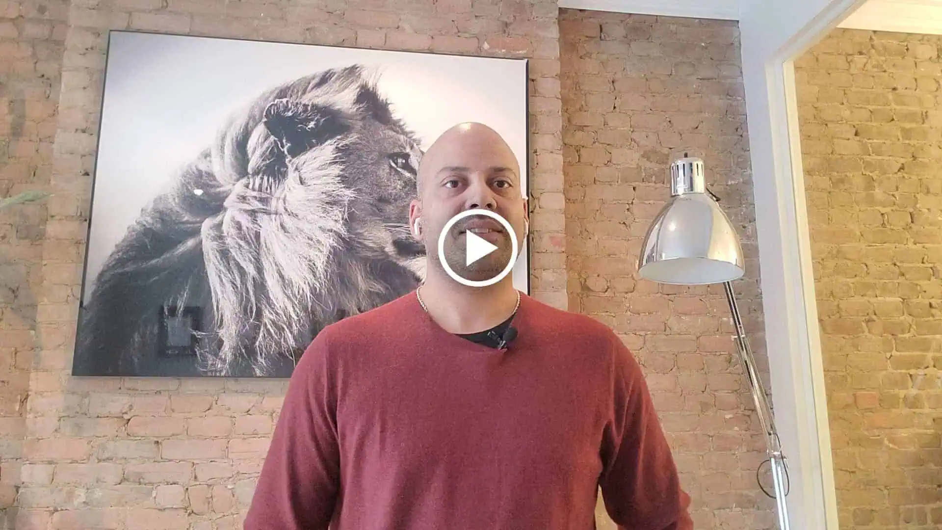 A man posing with a lion mural.