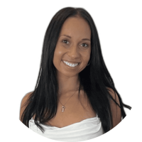 Woman with long straight black hair, wearing a white top and a necklace, smiling at the camera against a plain white background, showcasing her confident Javalogix style.
